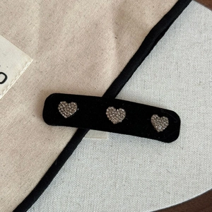 Vue macro de trois cœurs en strass sur une barrette en velours noir avec texture premium