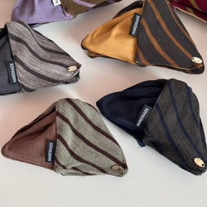 Detail of handmade color-block fabric triangle hair clips with textured canvas and metal buckle