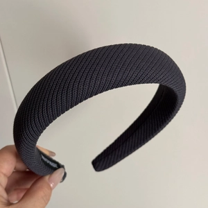 Gros plan détaillé d'un bandeau en tricot noir avec texture verticale et étiquette faite main