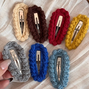 Detail showing seven colors of handmade crochet hair clips with metal BB clip backing
