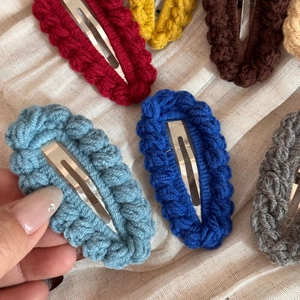 Detail of colorful hand-knitted oval crochet hair clips in various autumn candy colors