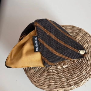 Detail view of the handmade knit fabric hair claw with golden metal tag and interior lining