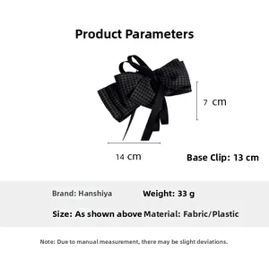 Detail view of large grey plaid bow hair clip with dimensions 14x7cm and 13cm base clip
