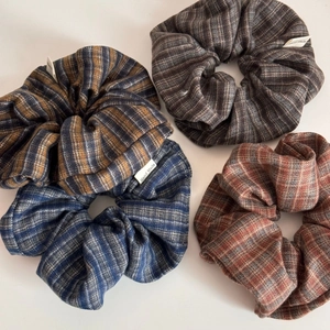 Detail of four vintage plaid and striped fabric scrunchies with Hand Made labels