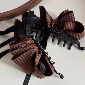 Close-up of vintage large hair clip with brown houndstooth and black satin ribbon detail