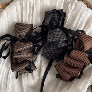 Three-piece vintage houndstooth bow hair clips with long satin ribbons on white linen