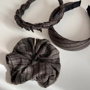 Close-up of deep brown fabric headband set with braided design and ribbed texture detail