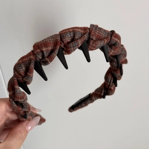 Detail of a plaid fabric headband featuring punk spikes and hand made inner printing