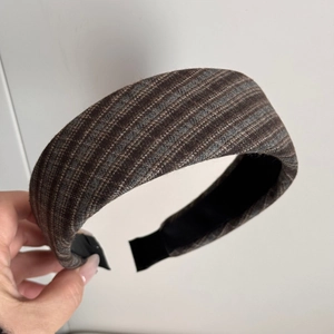 Detail view of the brown and gray plaid fabric texture on a wide padded headband