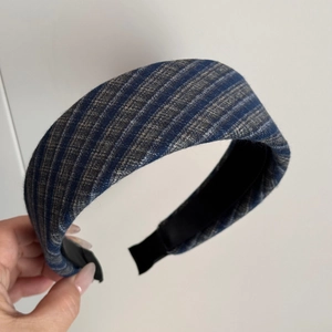 Close-up of thick blue plaid fabric headband with retro padded design and non-slip lining