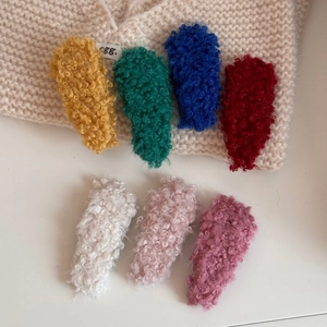 Detailed close-up of colorful plush tear-drop hair clips with soft faux lamb wool texture