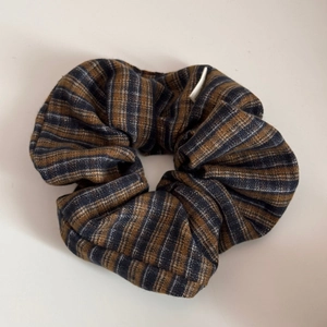 Detailed view of wide French fabric headband featuring brown and blue plaid pattern