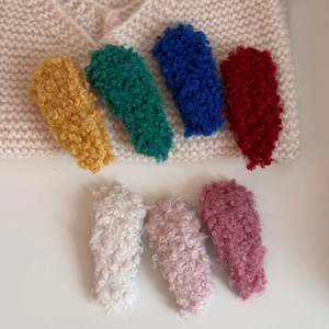 Group of colorful lamb wool hair clips showing soft plush texture and various vibrant colors
