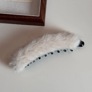 Dettaglio del fermaglio a banana in peluche con ecopelliccia e denti in plastica nera resistente