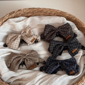 Five-piece set of plaid fabric bow banana hair clips in assorted neutral tones on a straw basket