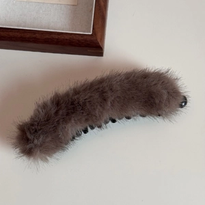 Dettaglio di un fermaglio a banana in morbido peluche marrone scuro soffice