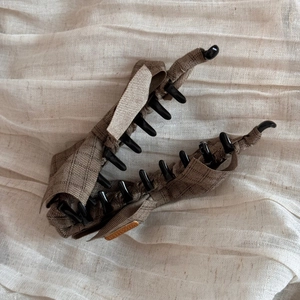 Close-up of large brown plaid fabric banana hair clip with sturdy black plastic teeth