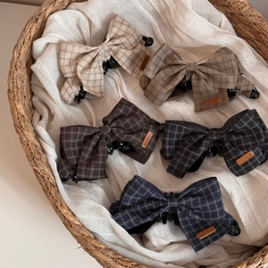 Set of five elegant plaid fabric bow banana hair clips in neutral colors in a wicker basket
