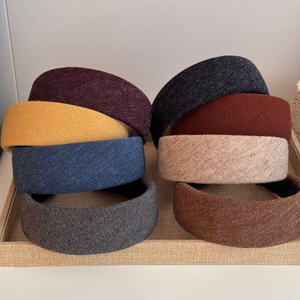 Wide padded knitted headbands in seven colors like burgundy and beige for a high-top look