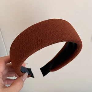 Detailed close-up of brown knitted wide headband showing thick texture and anti-slip lining