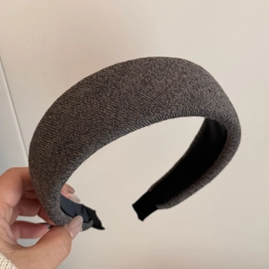 Close-up of thick knitted grey headband featuring non-slip lining and wide padded design