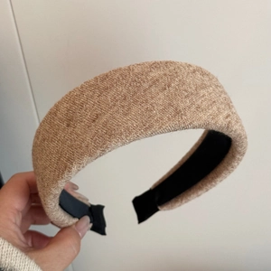 Detail of light brown knitted wide headband showing soft texture and non-slip inner lining