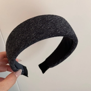 Macro detail of charcoal grey knitted padded headband with thick woven texture