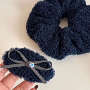 Detail of dark blue plush hair scrunchie and fleece hair clip with rhinestone bow