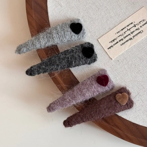 Detailed view of four colorful plush wool hairpins with flocked heart accents for autumn