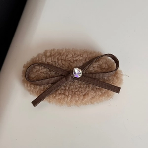 Close-up of plush camel brown scrunchie with dark brown bow and crystal center