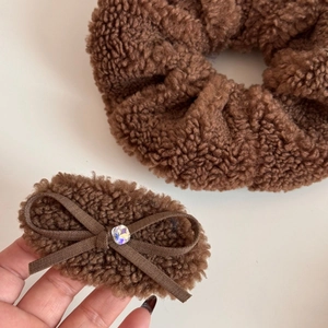 Detail of brown plush scrunchie and bow hair clip with sparkling rhinestone accent