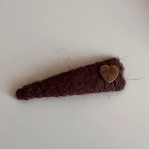 Detailed view of dark brown wool knit triangular hair clip with a small flocked heart