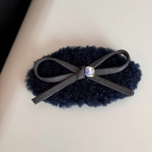 Macro shot of fluffy blue velvet scrunchie with ribbon bow and sparkling gemstone detail