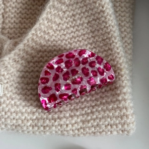 Detail view of pink leopard print acetate hair claw with gold Barrette France lettering