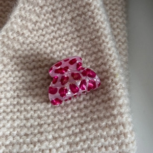 Detailed macro view of pink leopard print hair claw with golden Barrette la France text