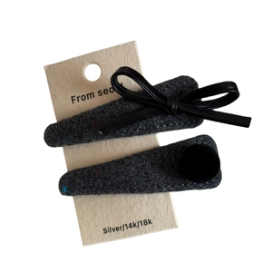 Elegant velvet and leather bow hair clips with tweed fabric wrap on white background