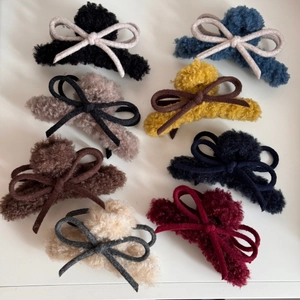 Plush faux fur claw clip with woven bow accent in eight assorted seasonal colors