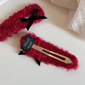 Detail of red knit hair clips with black bows and sturdy silver metal duckbill base