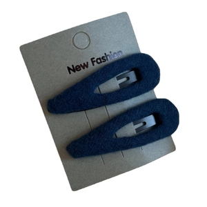Pair of deep blue plush teardrop hair clips on a grey display card for women