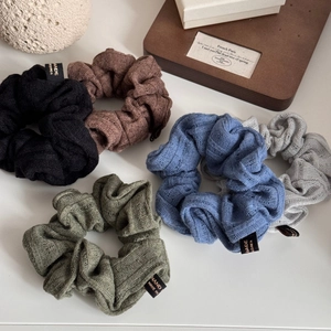 Close-up of five knitted scrunchies in retro autumn colors with striped texture detail