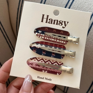 Detailed view of three vintage knit pattern hair clips on a branded display card