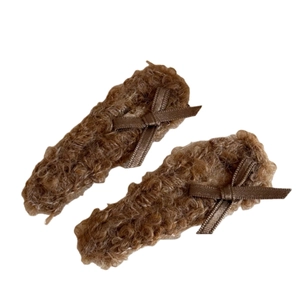 Pair of brown faux lamb wool bow hair clips for autumn winter styling on white background