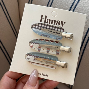 Three-piece set of acrylic hair clips featuring plaid, bear, and bow designs in hand