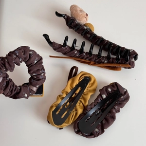 Hair accessory set featuring floral patterns and a cute plush bear on a brown hair claw clip