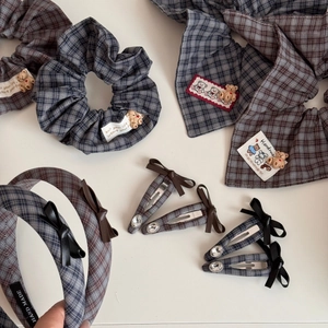 Flat lay of plaid hair accessory set with teddy bear resin accents and bows