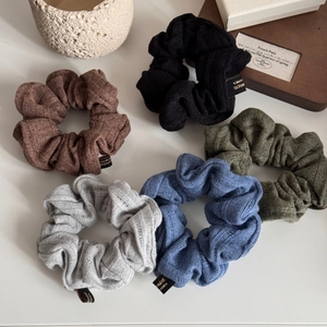 Detail of five knitted scrunchies showing ribbed texture and Made in Korea label