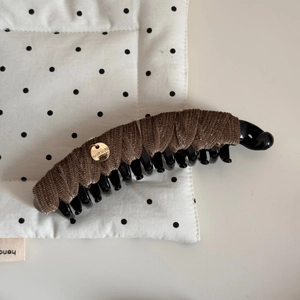 Détail d'une pince à cheveux banane en velours marron avec pendentif doré fait main