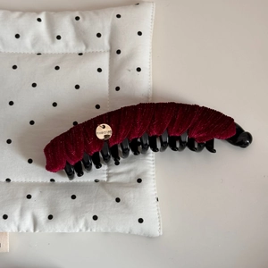 Détail de la pince banane en velours bordeaux avec breloque dorée faite à la main