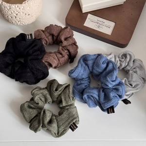 Five pieces of knitted striped scrunchies in retro colors with handmade labels