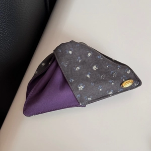 Detail of vintage floral fabric hair claw with golden metal brand plate and contrast lining